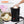 Black electric pressure cooker with a person adding ingredients, surrounded by pink flowers.